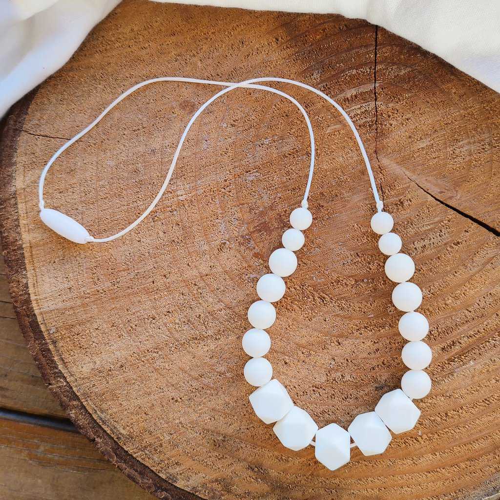 Collier d'allaitement Couleur blanc avec un fond en bois, 4 petites perles en silicone alimentaire de 9 mm, 8 moyenne perles en 12 mm et 5 perles en 15 mm.