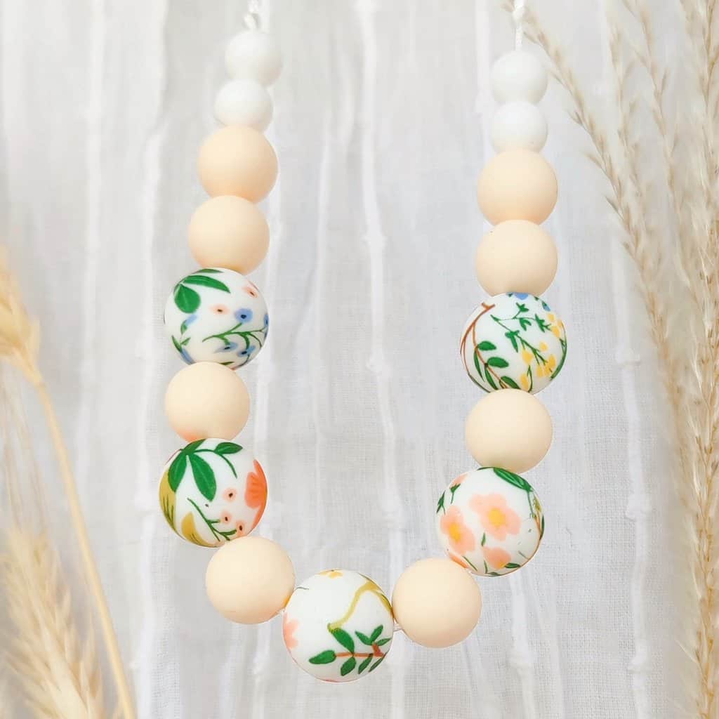 Collier allaitement de couleurs crème et fleurs, perles de silicone alimentaire avec fond décoratifs d'été